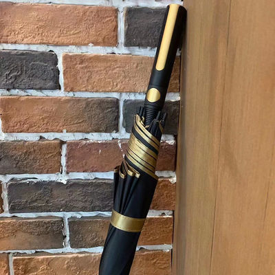 Paraguas de tela recubierta de oro con control semiautomático y mango dorado